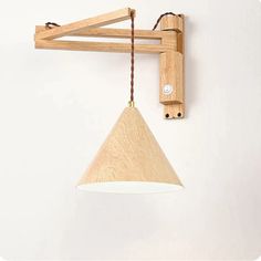 a wooden light fixture hanging from a white wall