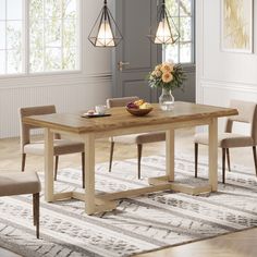 a dining room table with chairs and a bowl of fruit on the table in front of it