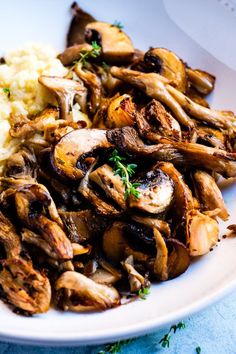 a white plate topped with mushrooms and mashed potatoes