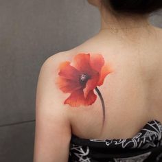 a woman with a red flower tattoo on her shoulder