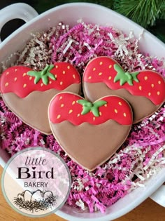 two decorated heart shaped cookies in a bowl