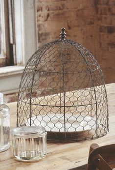 a bird cage sitting on top of a wooden table