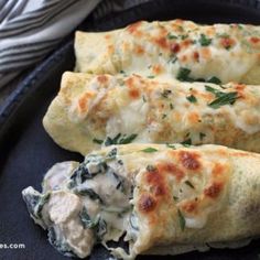 three cheesy pastries with spinach and cheese on a black plate, ready to be eaten