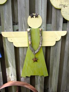 a wooden angel hanging on the side of a fence