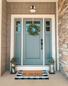 a blue front door with a welcome mat on it