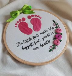 a cross stitch pattern with pink flowers and a handwritten quote on the bottom that says, the little feet make the happyest pair in heaven