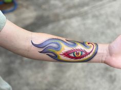 a person with a tattoo on their arm has an evil eye and flames coming out of it