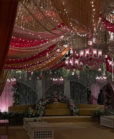 a man is standing in the middle of a room decorated with flowers and chandeliers