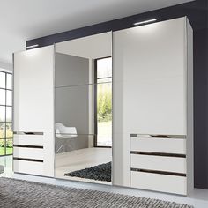 a modern white and black bedroom with mirrored closet doors on the wall, carpeted flooring and large windows