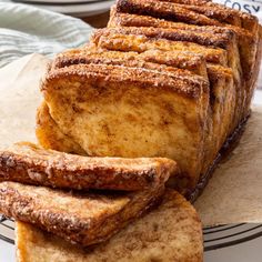 slices of french toast sitting on top of a white and black plate next to some napkins