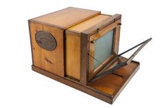 an old fashioned wooden tv set with no screen on it's stand and one door open