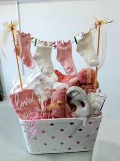 a basket filled with baby's clothes and socks hanging from a line on a clothesline