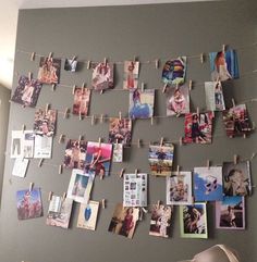 many pictures are hung on clothes pins and pinned to the wall