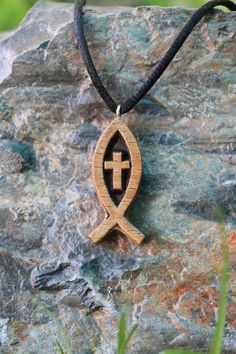 a wooden necklace with an egyptian cross on it sitting on top of a stone slab