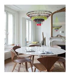 a dining room table with chairs and a chandelier hanging from it's ceiling