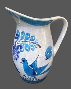 a blue bird painted on a white pitcher