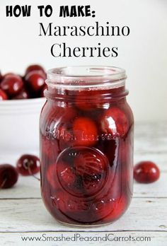 a jar filled with cherries sitting on top of a table