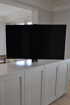 two flat screen televisions sitting on top of a white counter