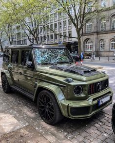 the green jeep is parked on the side of the street