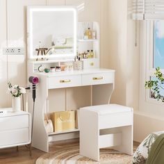 a white dressing table with a mirror, stool and drawers in front of a window