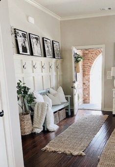 a living room filled with lots of furniture and pictures on the wall next to a door