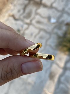 a person holding two gold rings in their hand