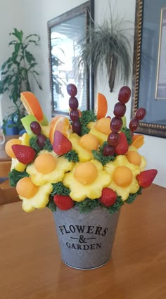 a bucket filled with fruit sitting on top of a wooden table