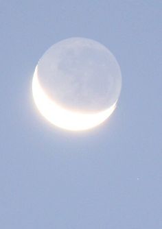 the moon is visible in the clear blue sky