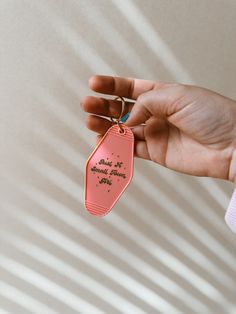 a hand holding a pink keychain that says, please to all those who leave us