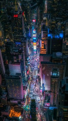 an aerial view of a city at night with lots of tall buildings and cars on the street