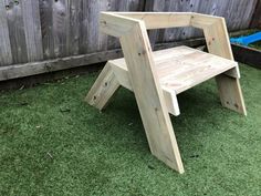 a wooden step stool sitting in the grass