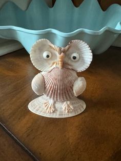 an owl figurine sitting on top of a wooden table