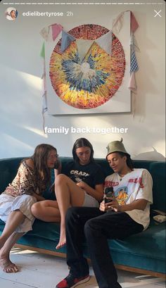 three people are sitting on a couch together