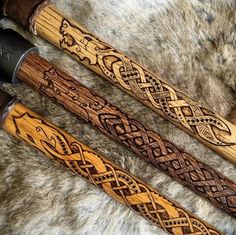 two wooden canes with designs on them