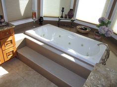 a large white bath tub sitting inside of a bathroom