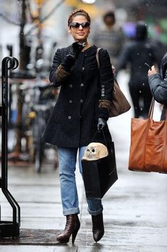 a woman is walking down the street talking on her cell phone and holding an umbrella