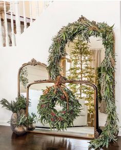 a mirror sitting on top of a wooden table next to a potted plant in front of it