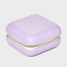 a purple case with gold zippers on the bottom and inside, sitting on a white surface