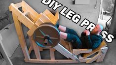 a man sitting in a chair made out of wood with the words diy leg press on it