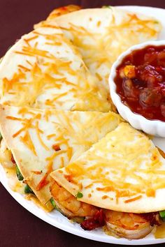 two quesadillas on a plate with salsa and tortilla