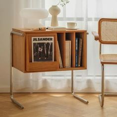 a wooden book shelf sitting next to a chair