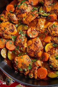 a pan filled with chicken, carrots and potatoes