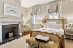 a bedroom with a fireplace and white walls