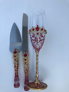 a knife, fork and wine glass sitting next to each other on a white surface