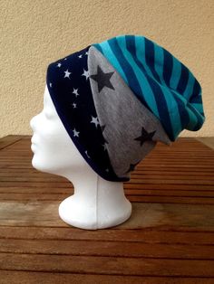 a white mannequin head wearing a blue and gray hat with stars on it