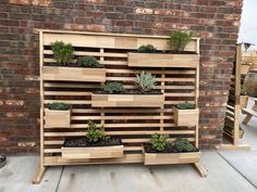 a wooden planter filled with succulents and plants on top of a patio