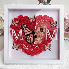 there is a frame with flowers and butterflies in the shape of a heart that says mom