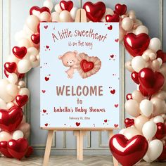 a welcome sign surrounded by balloons in the shape of heart shapes and an image of a teddy bear