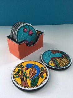 three plates with designs on them sitting next to a box