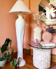 a white lamp sitting on top of a table next to a mirror